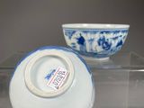 two blue and white bowls sitting on a clear table