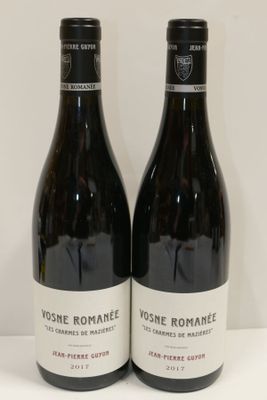 deux bouteilles de vin posées sur une table l'une à côté de l'autre