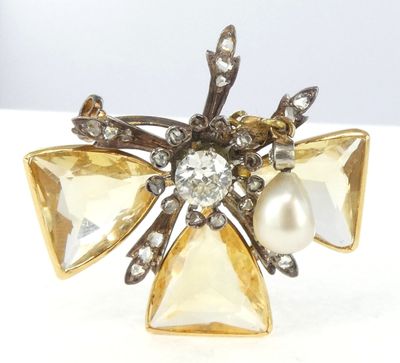 une photo en gros plan d'une broche ornée de perles et de cristaux