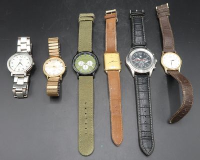 several different watches are lined up on a black surface