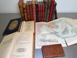 several old books are sitting on a table next to a pile of old books