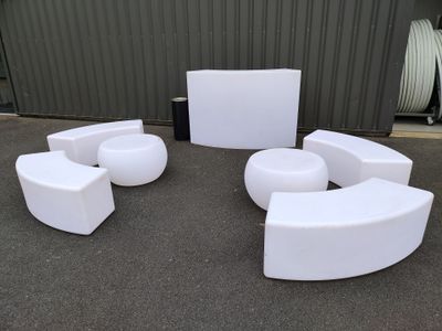 several white chairs and tables in front of a building
