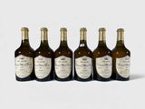 six bouteilles de vin sont alignées sur une surface blanche