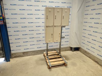 une photo représentant une caisse métallique posée sur une palette devant un mur