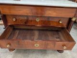 a wooden dresser with a marble top on wheels