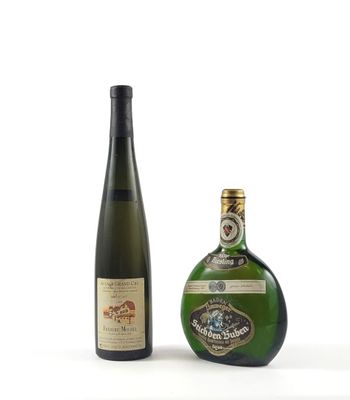 deux bouteilles de vin posées l'une à côté de l'autre sur une surface blanche
