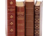 trois livres sont empilés sur une surface blanche