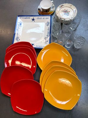 many different colored plates and cups on the table