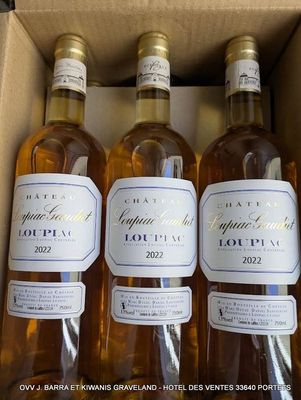 trois bouteilles de vin blanc dans un carton, avec des étiquettes dessus