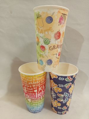three cups with different designs on them sitting on a table