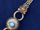 a close up of a gold bracelet with a turquoise stone on it