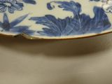 a blue and white plate with flowers on it on a table