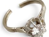 une bague sertie d'un diamant, sur fond blanc