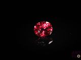 a close up of a red diamond on a black surface