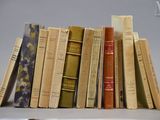 une pile de vieux livres posée sur une étagère à côté d'un ordinateur portable
