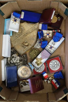 une boîte remplie de médailles et d'autres objets qui s'y trouvent