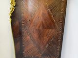 a small wooden cabinet with a gold decoration on it