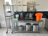 a kitchen with a stainless steel table with pots and pans on it