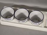 three cups sitting on a tray with a spoon on it