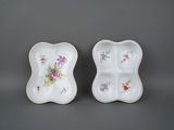 pair of porcelain dishes with floral designs on them on a gray surface