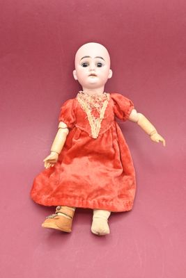 an image of a doll is sitting on a pink surface