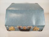 a small blue suitcase sitting on a white surface