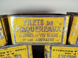 several tins of old french food are stacked on top of each other