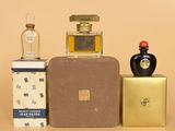 three bottles of perfume sitting on top of a table next to a box