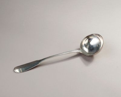 a silver spoon with a spoon handle on a white surface