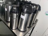 many different types of coffee pots on a metal shelf