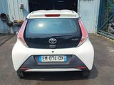 a small white car parked in front of a garage
