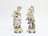 two figurines of a man and a woman sitting on a stool