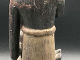 a small figurine of a person sitting on a table