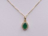 a gold necklace with a green stone and diamonds on it
