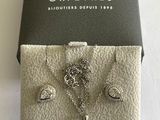 une boîte sur laquelle sont posés un collier et des boucles d'oreilles en argent