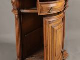 an old wooden corner cabinet with a drawer on top of it