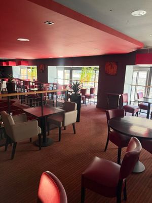 tables and chairs in a restaurant with red walls and a red ceiling