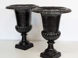 two black vases sitting next to each other on a table