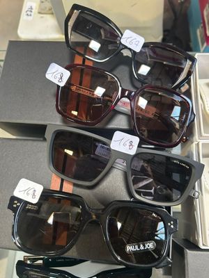 Plusieurs paires de lunettes de soleil sont exposées dans une vitrine.