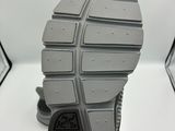 la semelle d'une paire de chaussures grises sur une surface blanche