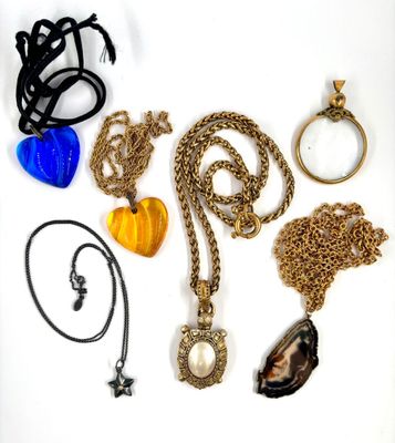 de nombreux colliers et bracelets de toutes sortes disposés sur une surface blanche