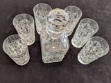 six verres et une carafe sur la table