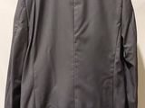 the back of a jacket hanging on a hanger against a white wall
