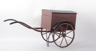 une petite charrette en bois sur laquelle est posée une caisse en bois