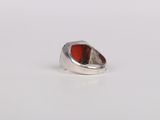 a close up of a silver ring with a red stone in it