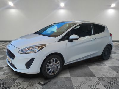 a white ford fiesta parked on a checkered tile floor