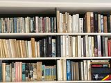 a book shelf with many books on it in a room