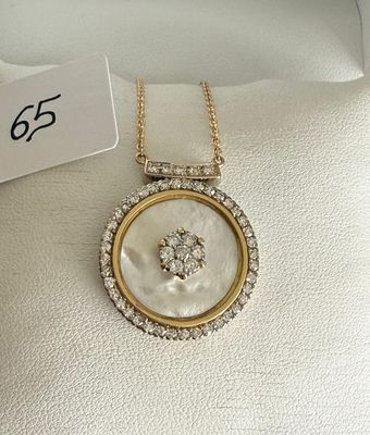 a close up of a necklace on a white pillow with a tag on it