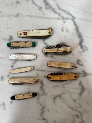 de nombreux types de couteaux de poche posés sur la table