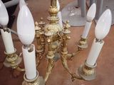 a gold chandelier with five white candles on it